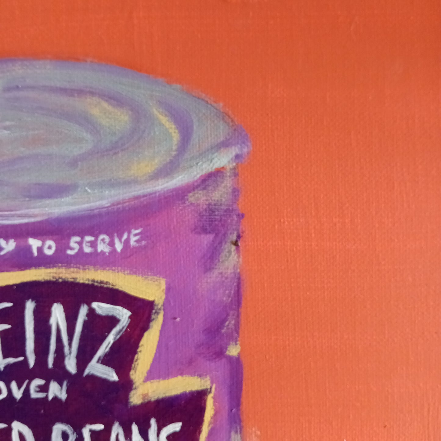 Close-up of a purple baked beans can with 'heinz' branding on an orange background